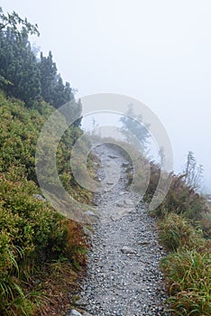 Horský turistický chodník na jeseň pokrytý hmlou