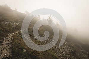 Mountain tourist trail in autumn covered in mist - soft vintage