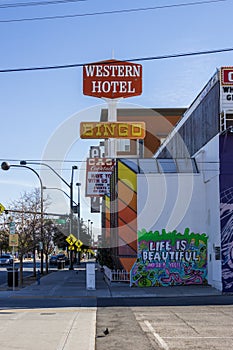 The Western Hotel with a colorful wall mural and cars on the street with blue sky at the Fremont Street Experience in downtown