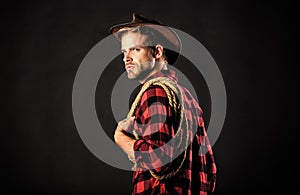 Western life. Man wearing hat hold rope. Lasso tool of American cowboy. Lasso is used in rodeos as part of competitive photo