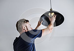 A western man changing lightbulb