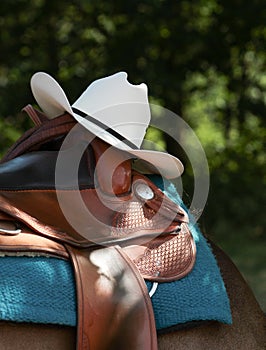 Western saddle with cowboy hat and leather harness