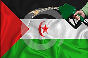WESTERN SAHARA flag Close-up shot on waving background texture with Fuel pump nozzle in hand. The concept of design solutions. 3d