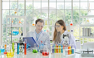 A western scientists couple working on test tube to analysis and develop vaccine of covid-19 virus in lab or laboratory in