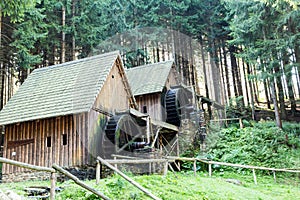 Western style pioneer frontier water mill wheel wooden building in the forest