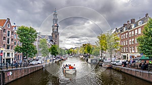 Westertoren tower seen from the intersection of the Leliegracht and Prinsengracht canals in the Jordaan neighborhood in Amsterdam photo