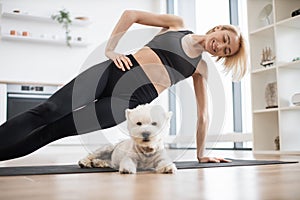 Westie suiting for yoga workout with lady in Vasisthasana