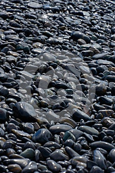 Wet Black pebble stones island in Koh hin ngam, Tarutao National Park, Satun, Thailand