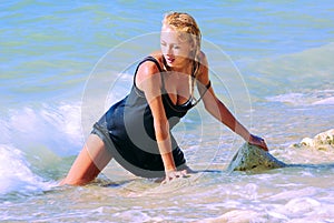 Wet blond kneeling in surf