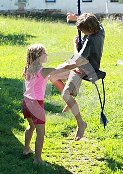 Wet boy and girl on a swing