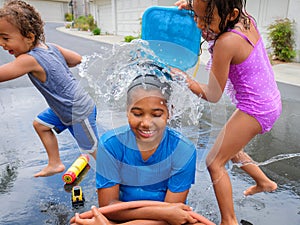 Wet Brother and Sisters Playing Outside with Water