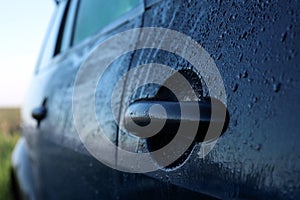 Wet car with door handle outdoors, closeup view