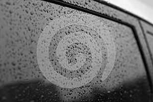 Wet car glass. Black glass surface with raindrops. Natural texture of rain drops on glass, backdrop background for design