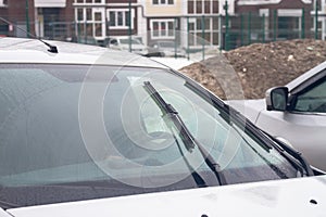 Wet car windshield during rain in water drops