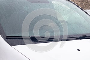 Wet car windshield during rain in water drops