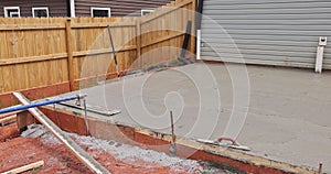 Wet cement concrete foundation mortar is leveled using special steel trowel by a construction worker.