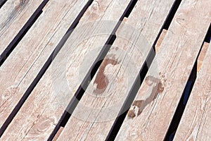 Wet child footprint on brown wooden background