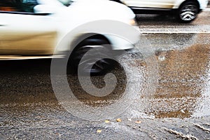 Wet city road and blurred in motion cars