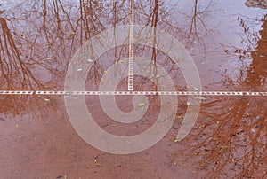 Wet clay tennis court with puddles after the rain, the soil can not absorb water