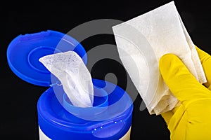 A wet cleaning cloth in a plastic container. Handkerchief with a yellow glove