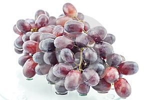 Wet cluster of grapes on a glass table
