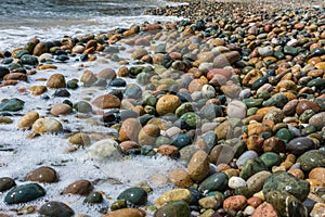 Wet, colorful, big pebbles on Mediterranean beach.