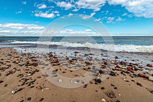 Wet, colorful pebbles on a sandy beach