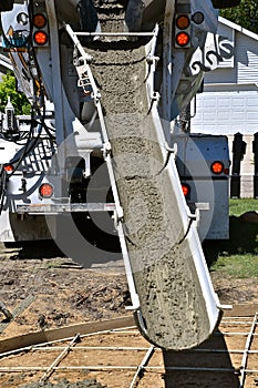 Wet concrete coming dow a chute of a emend truck