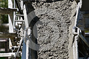 Wet concrete pours out of a ready-mix truck. photo