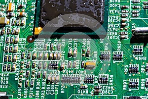 wet digital circuit board with microprocessors and components, closeup full-frame macro background