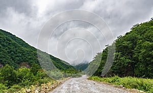 Wet dirt road in mountainous area at rainy day