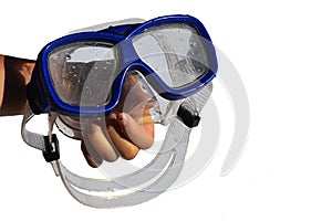 Wet diving half mask with blue frame held in small girl left hand, white background