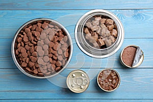 Wet and dry pet food on light blue wooden table, flat lay