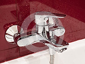 Wet faucet covered by water drops in a modern bathroom