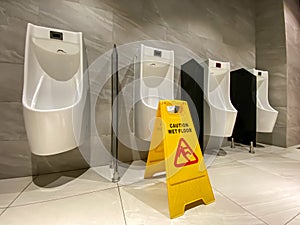 Wet floor alert sign during cleaning process in public toilet