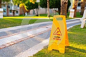 Wet floor caution sign on hotel stone path