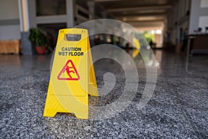 Wet floor caution sign on a slippery floor at the indoor public hallway