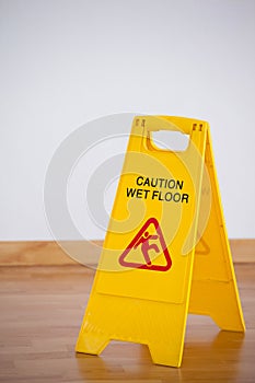 Wet floor caution sign on wooden floor