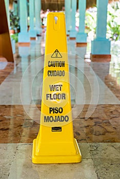 Wet floor and caution warning sign in Spanish and English photo