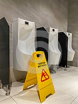 Wet floor cautious sign in public men toilet