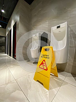 Wet floor cautious sign put at urinals area in male toilet