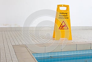 Wet floor sign by indoor swimming pool