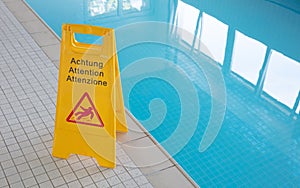 Wet floor sign by indoor swimming pool