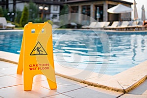 Wet floor sign by luxury swimming pool
