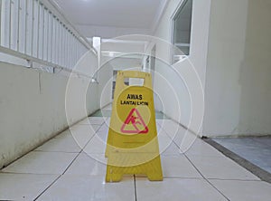 The wet floor sign is placed on the floor that has just been mopped photo