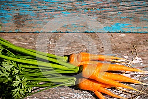 Wet fresh carrots with leaves on the wooden