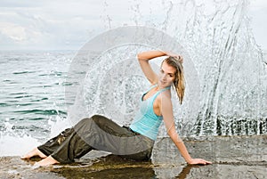 Wet girl sitting near the ocean