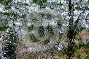 Wet glass with raindrops overlooking the street