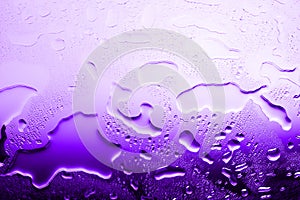 Wet glass surface in drops of water, violet gradient, texture of spilled water in bright purple colors, abstract background