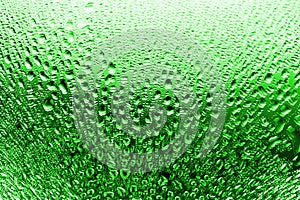 Wet glass in water drops, green bottle color, gradient, misted glass texture background close up